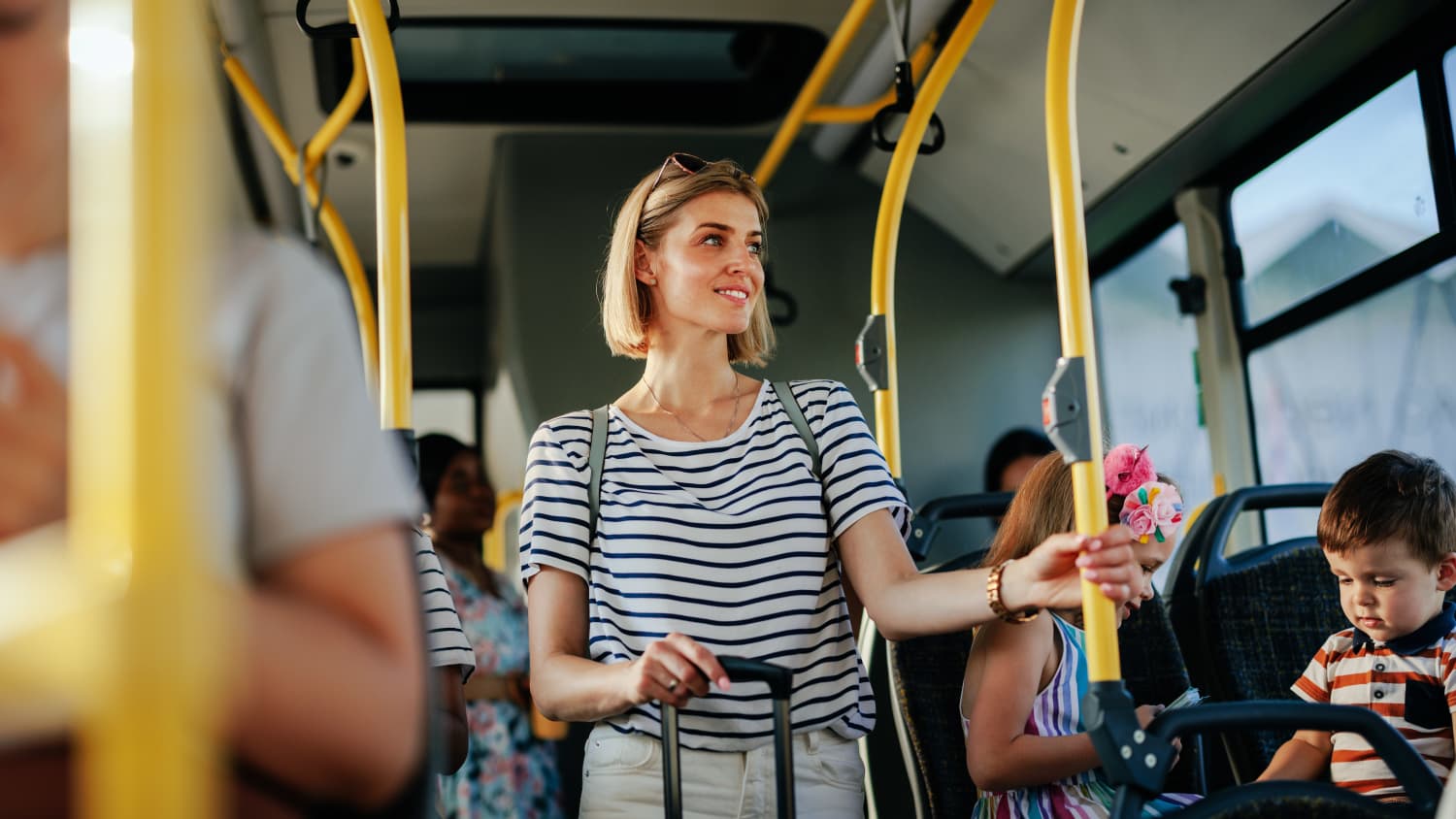 Eine Frau fährt im Bus und hält sich an der stange fest