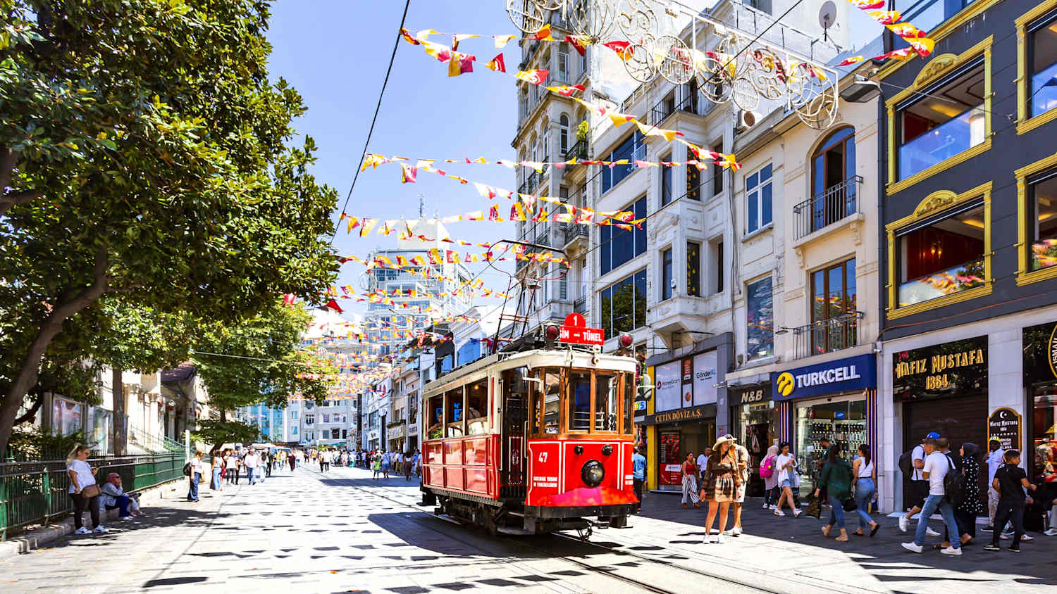 Eine rote, historische Strassenbahn fährt auf der Istiklal Caddesi - eine bekannte Strasse - in Istanbul