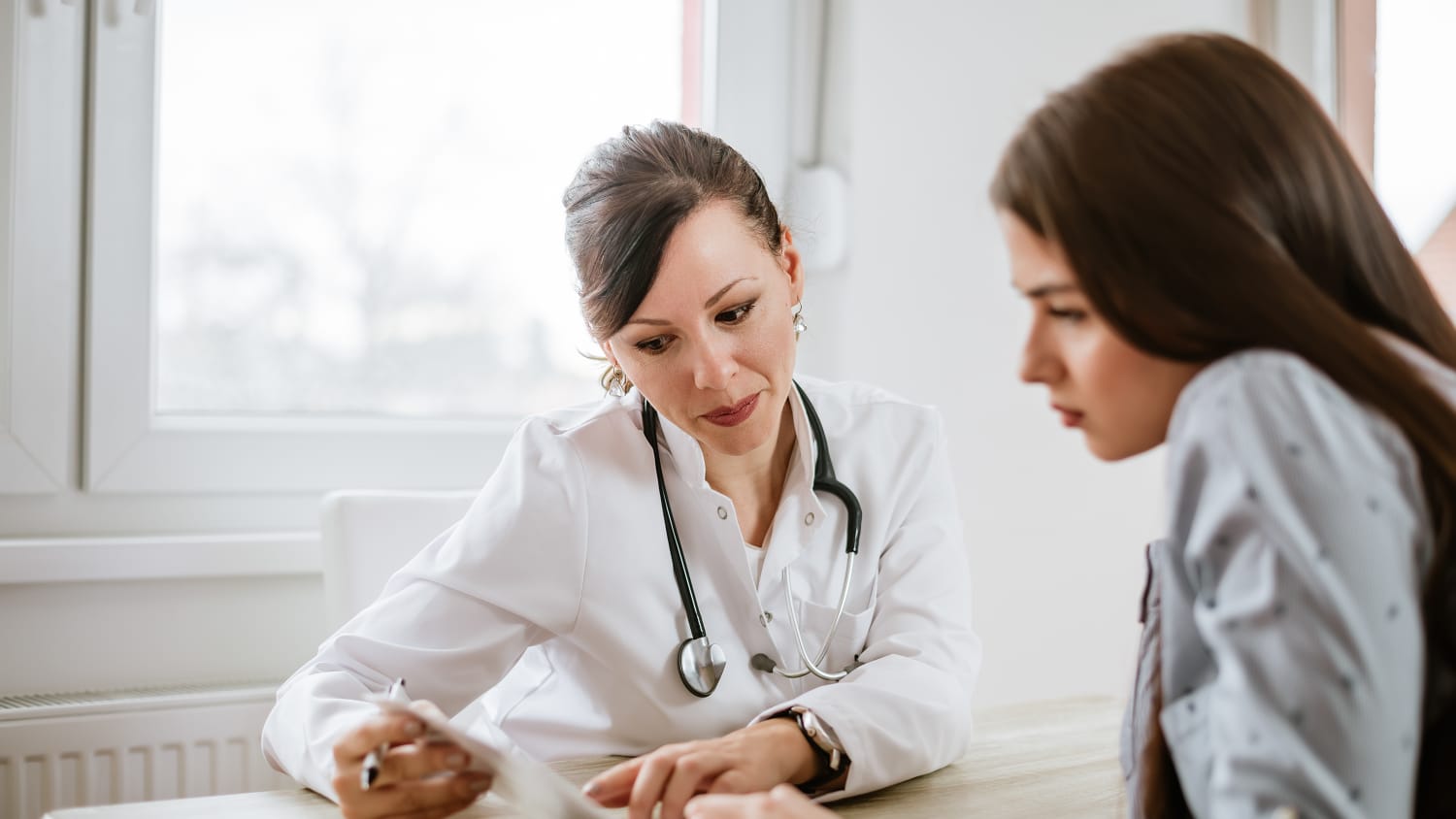 Eine Patientin im Gespräch mit ihrer Ärztin in der Praxis