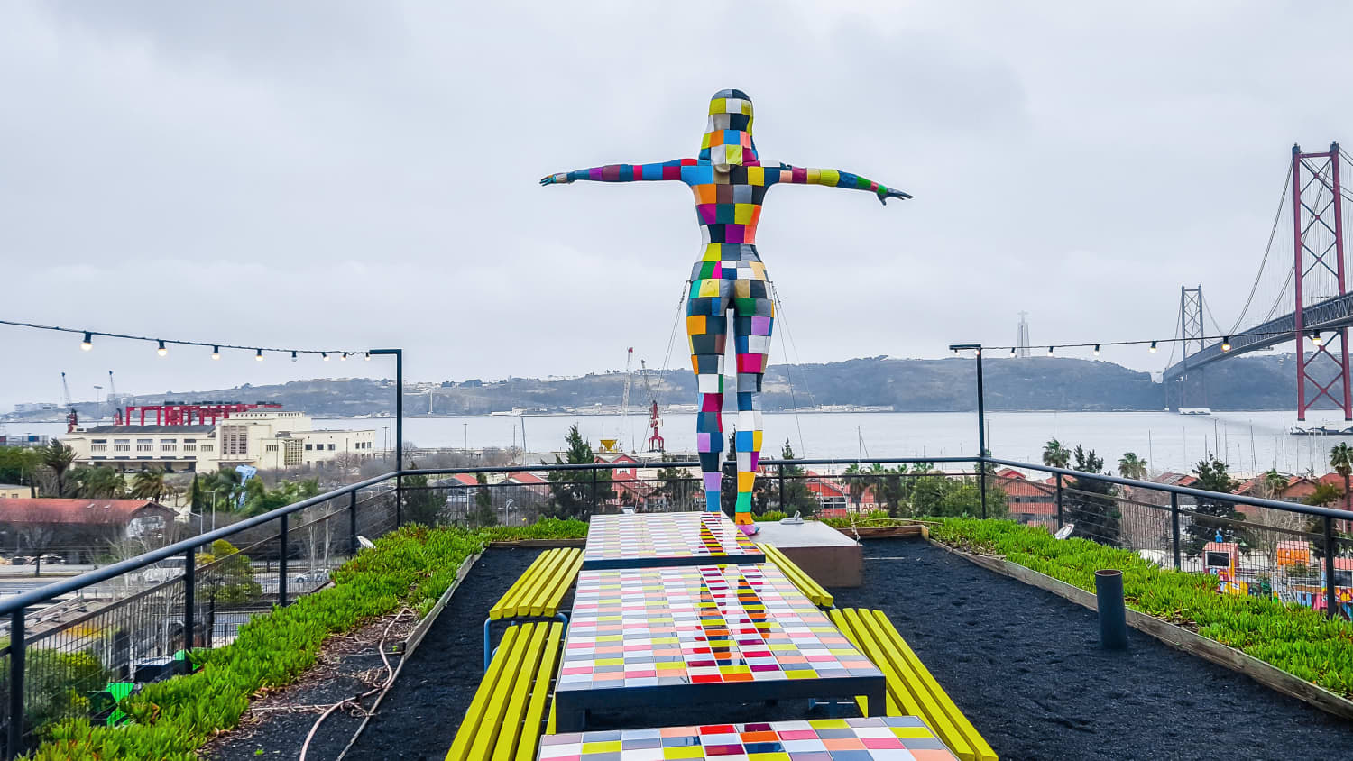 Eine farbenfrohe Skulptur einer flugbereiten Frau in der LX Factory in Lissabon.