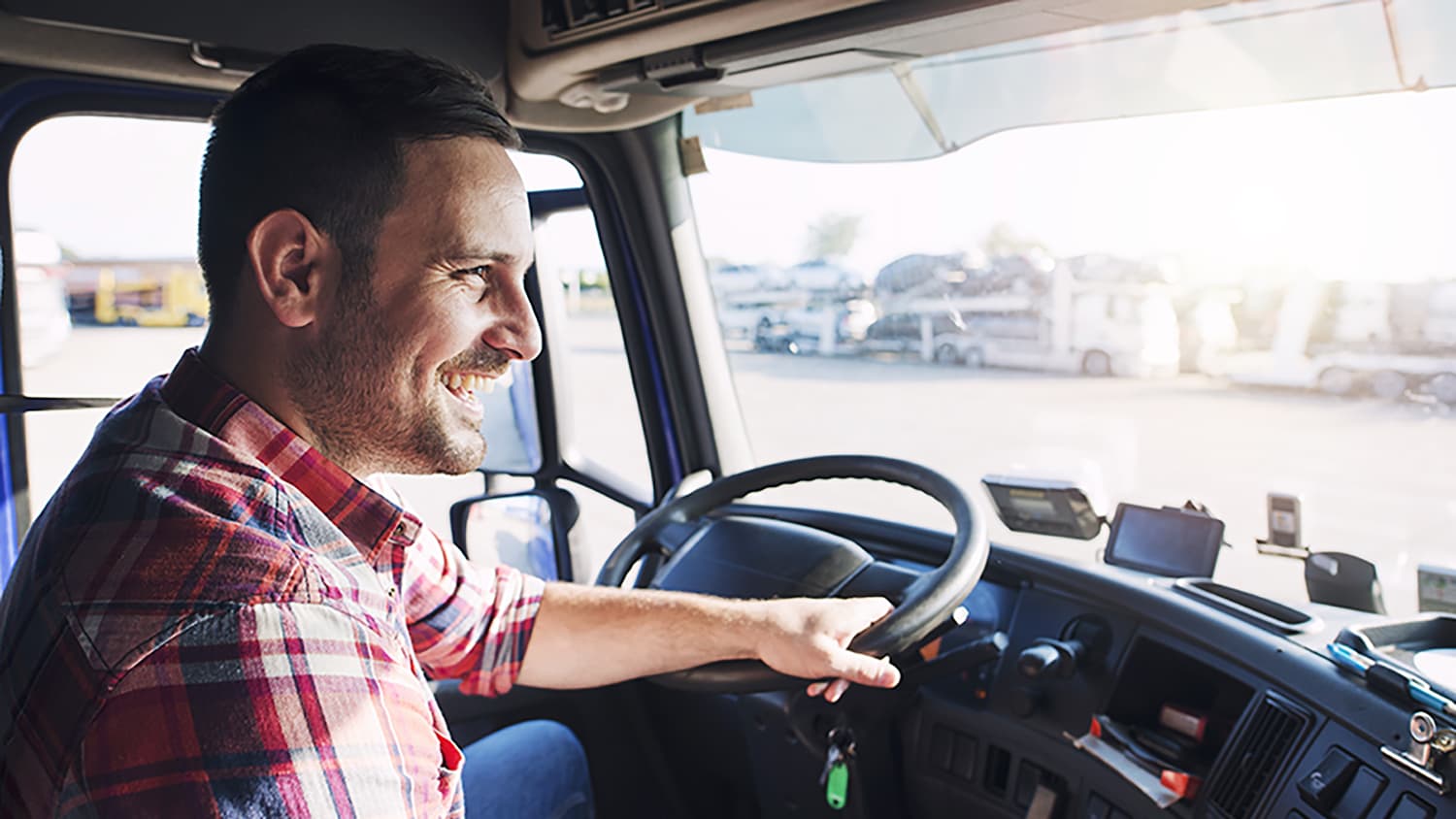 Ein Mann fährt lächelnd einen LKW