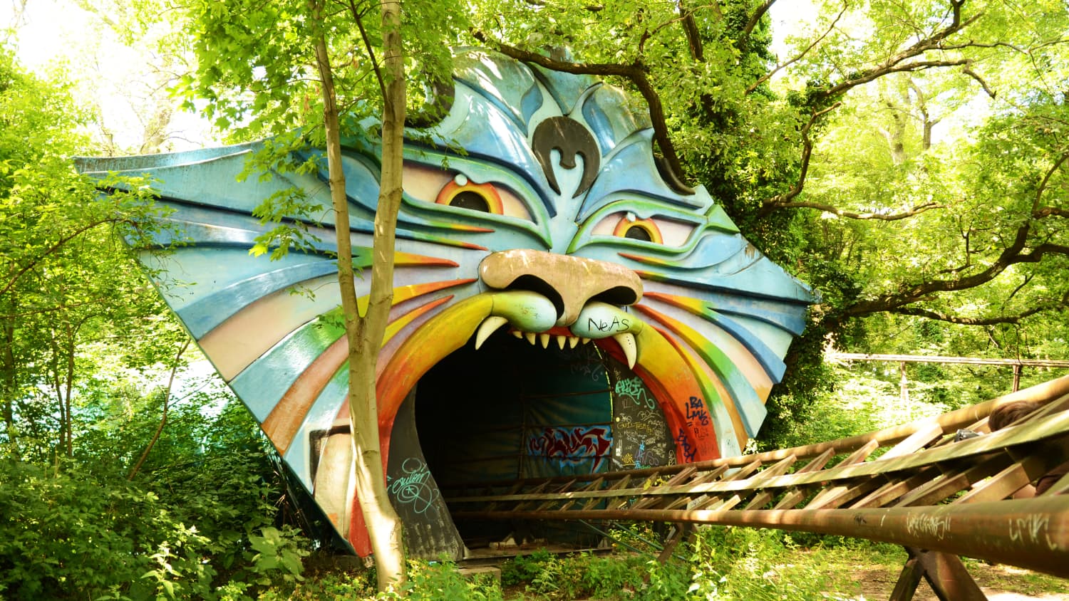 Ein Tigermaul, in das Achterbahnschienen führen in einem Park