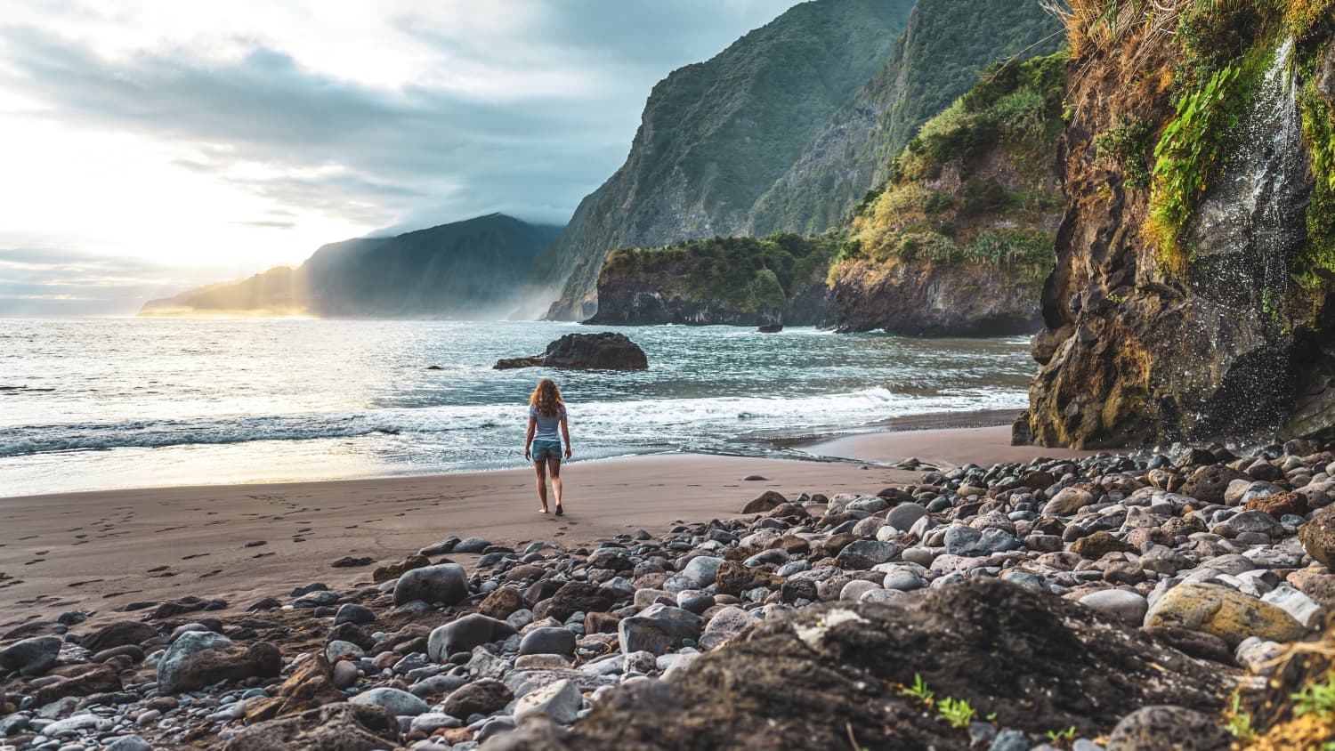 Eine Frau läuft am Seixal Beach auf Madeira