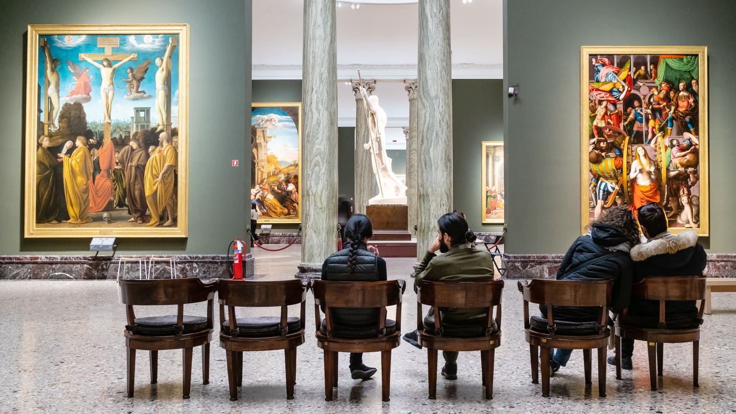 Besucher sitzen auf Stühlen vor Gemälden in der Pinacoteca di Brera Art Galerie in Mailand