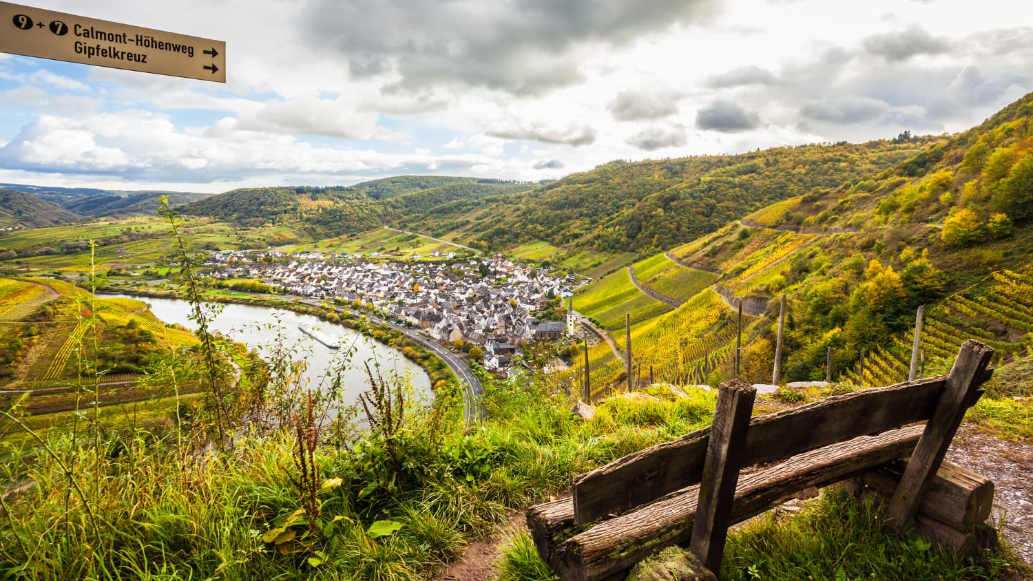 Eine Bank hoch oben, mit Blick auf einen Fluss und eine Stadt