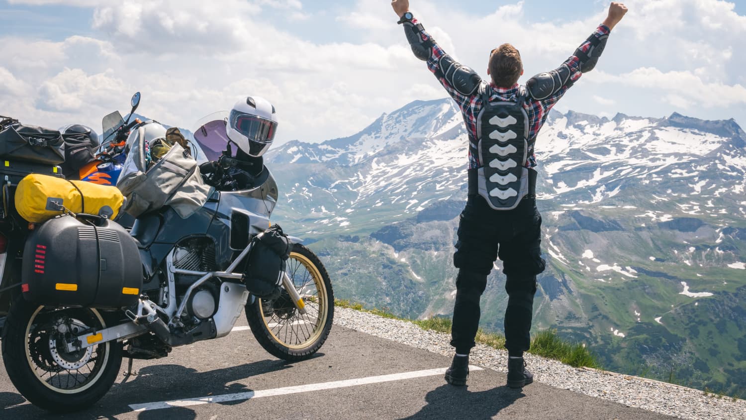 Ein Motorradfahrer freut sich an einem Rastplatz mit seinem Motorrad