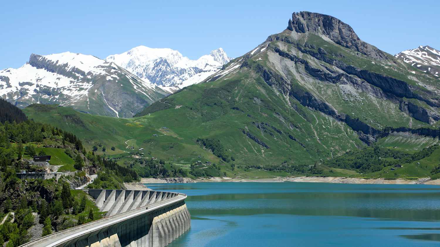 Motorradfahrer am Cormet de Roselend Damm in den französischen Seealpen mit beeindruckendem Bergpanorama.