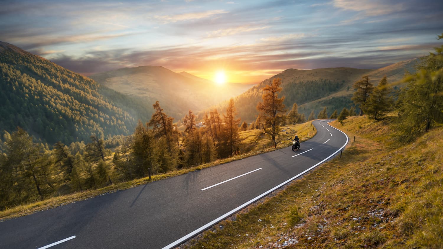 Motorradfahrer auf einer Passstraße im Herbst