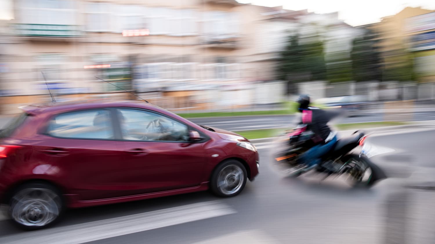 Ein Motorradfahrer biegt an einer Kreuzung ab und wird dabei von einem Auto übersehen