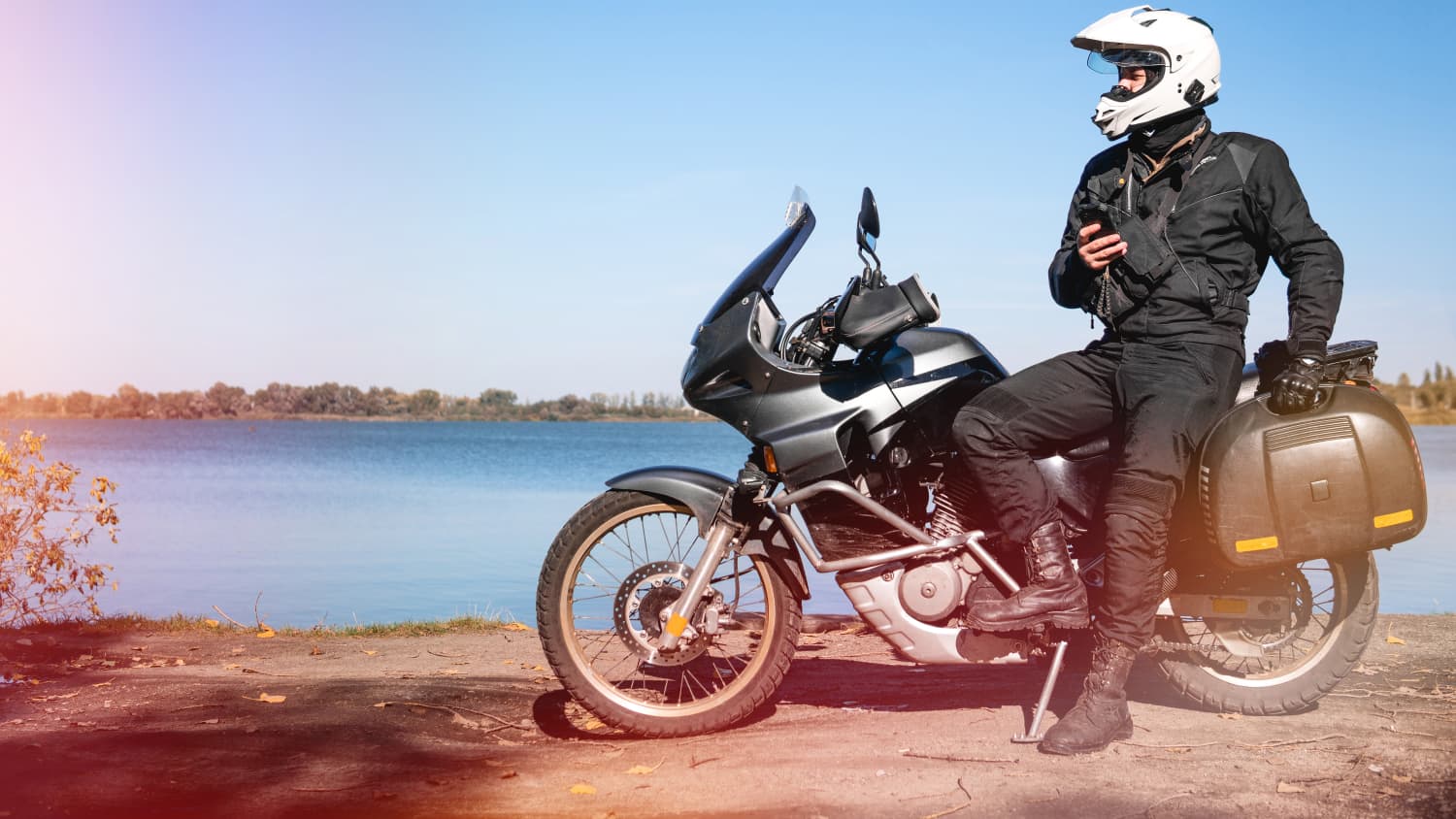 Motorradfahrer steht vor seinem Motorrad