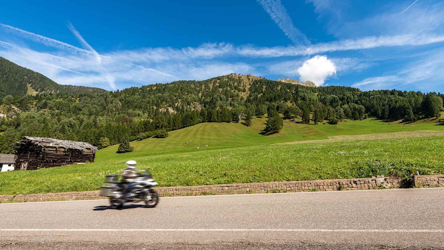 Ein Motorrad fährt durch die Bergwelt im Trentino