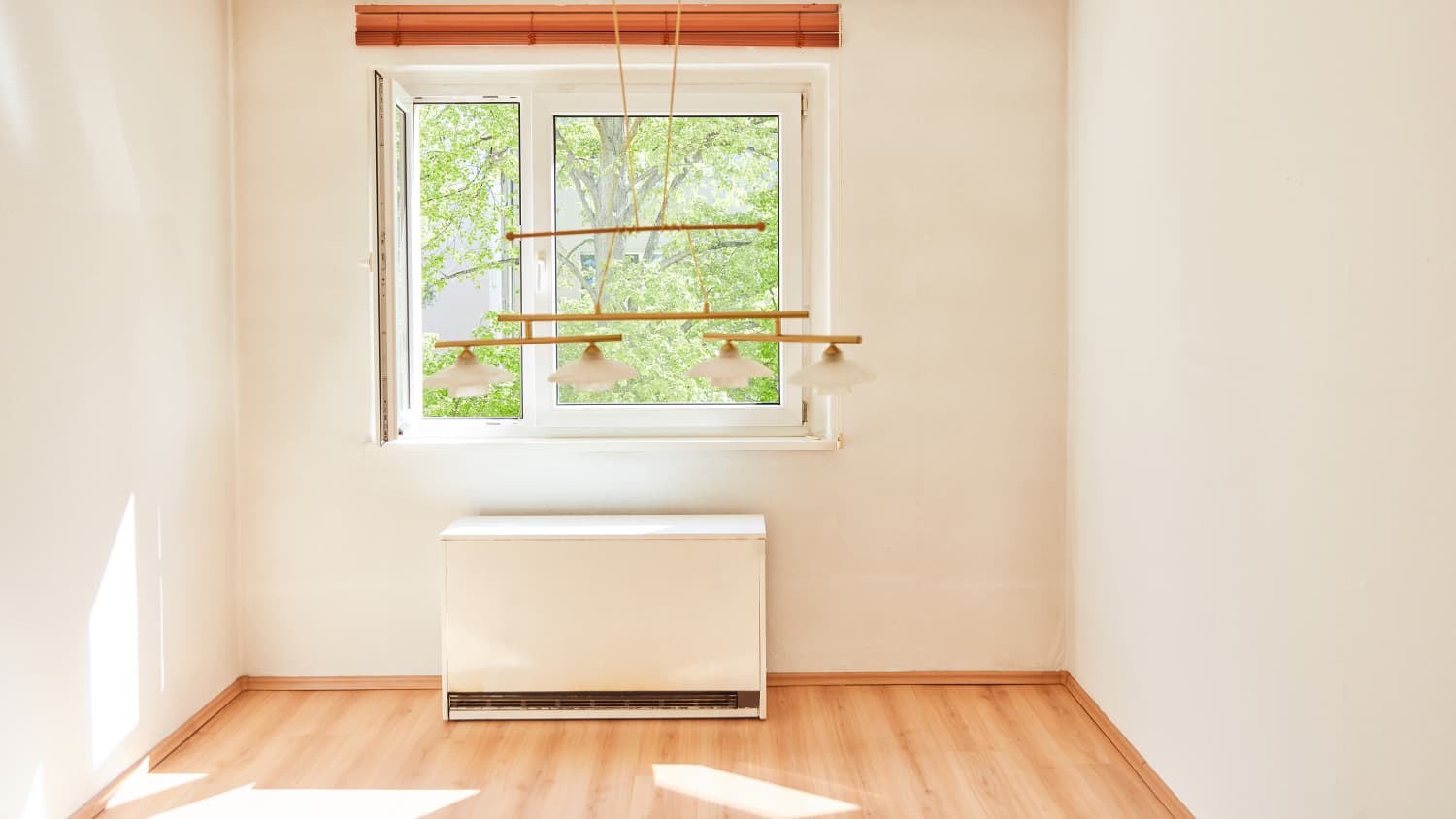 Ein heller Raum mit Fenster in dem ein Nachtspeicherofen verbaut ist