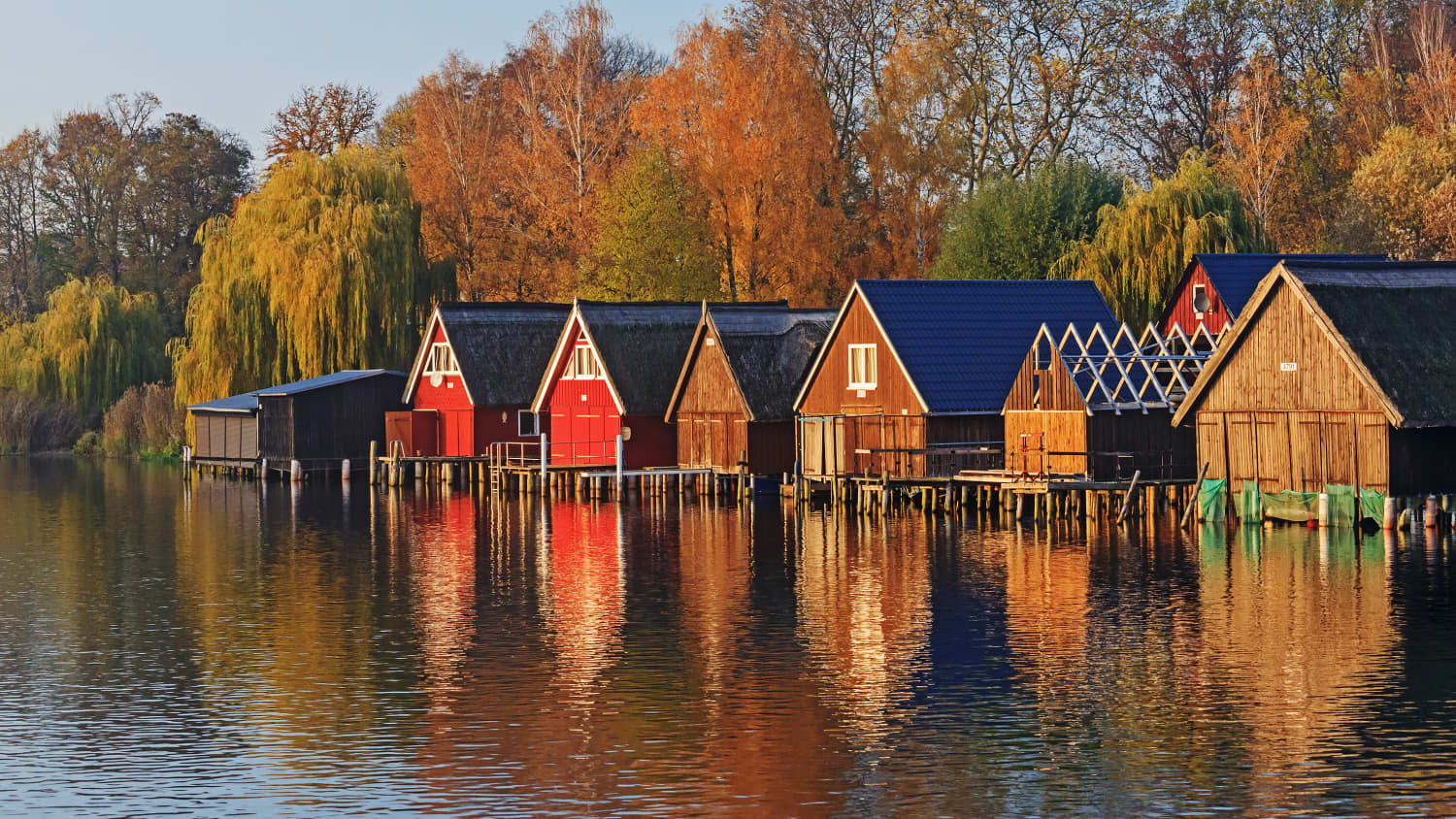 Bootshäuser an einem See im Herbst