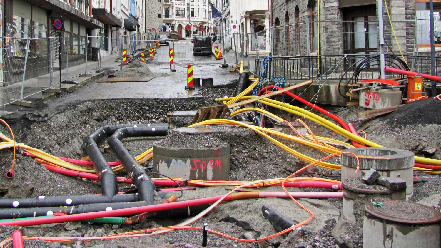 Eine geöffnete Straße mit vielen Rohren und Kabeln