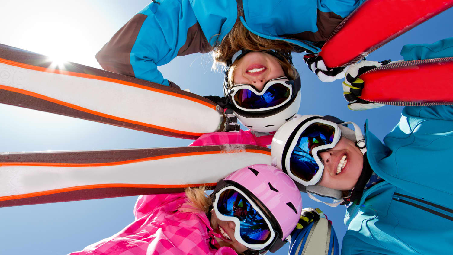 Gruppe von jungen Skifahrern mit Brillen schaut von oben in die Kamera