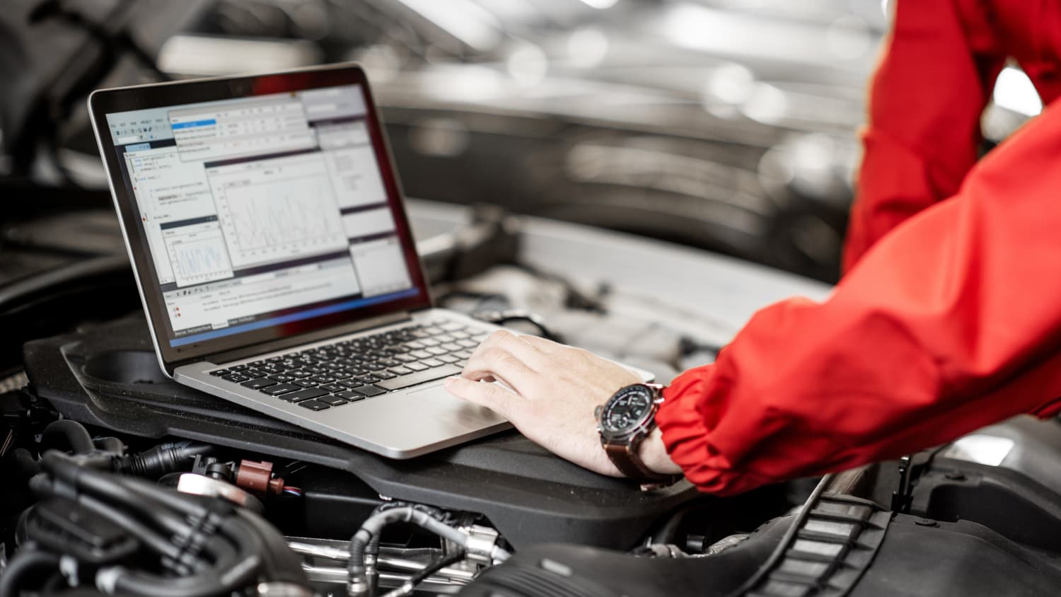 Mechaniker wertet Daten eines Autos mit Laptop aus
