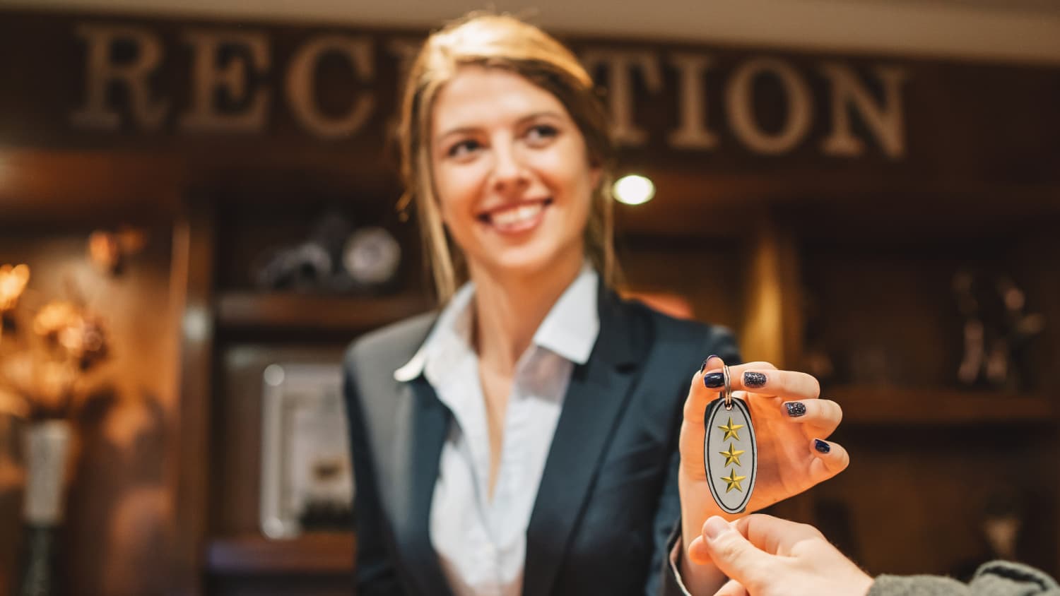 Ein Mann, der gerade im Hotel ankommt und nach dem Check-in Schlüssel von seinem Zimmer erhält
