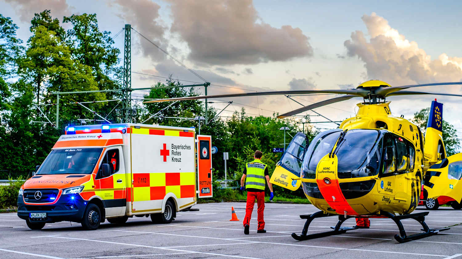 Ein Krankenwagen und ein ADAC Hubschrauber stehen einem Unfallort