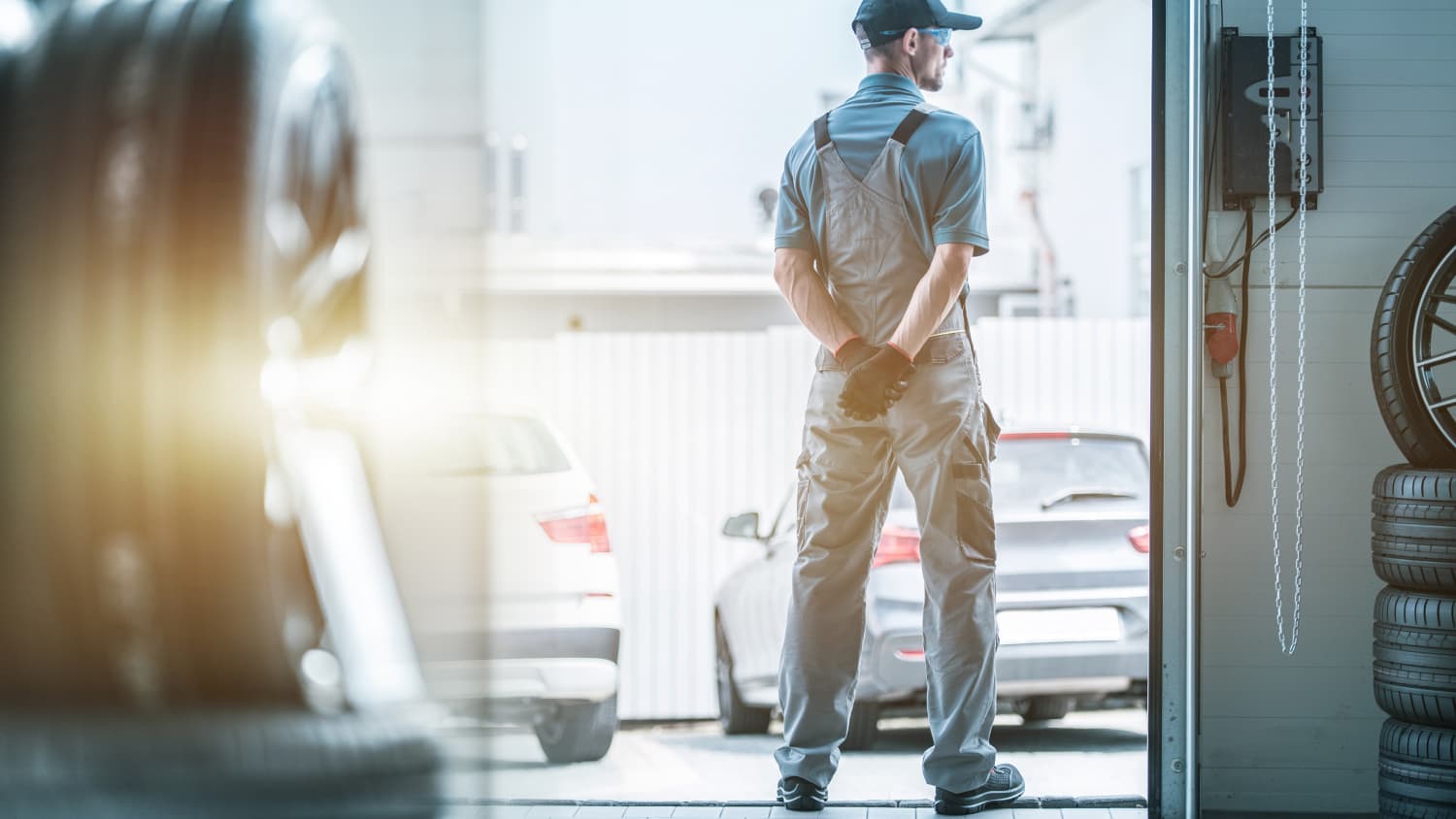Automechaniker hält Ausschau nach Lieferanten der Ersatzteile um Auto fertig reparieren zu können