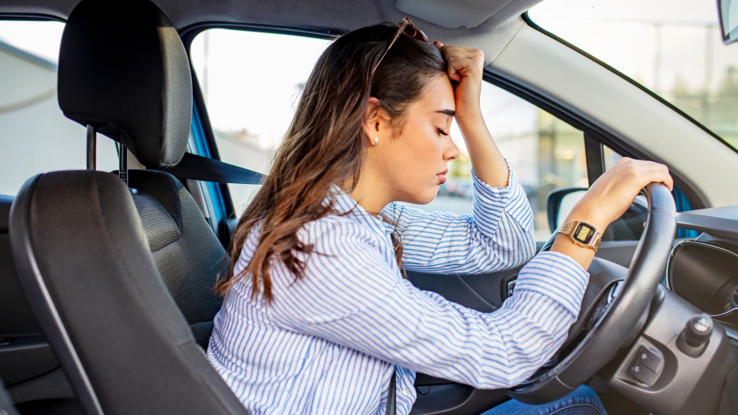 Eine verzweifelte Frau am Steuer Ihres Autos