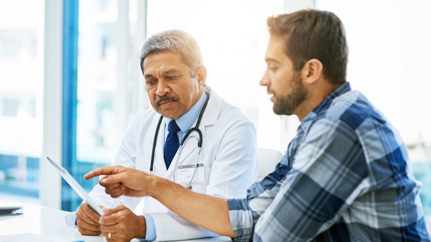 Ein Patient im Gespräch mit dem Arztin der Praxis
