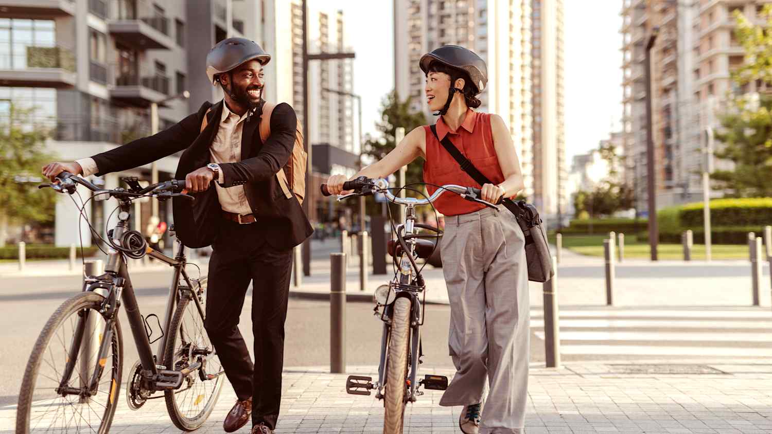 2 Arbeitskollegen die zusammen in der Mittagspause ihr Fahrrad schieben und sich dabei unterhalten