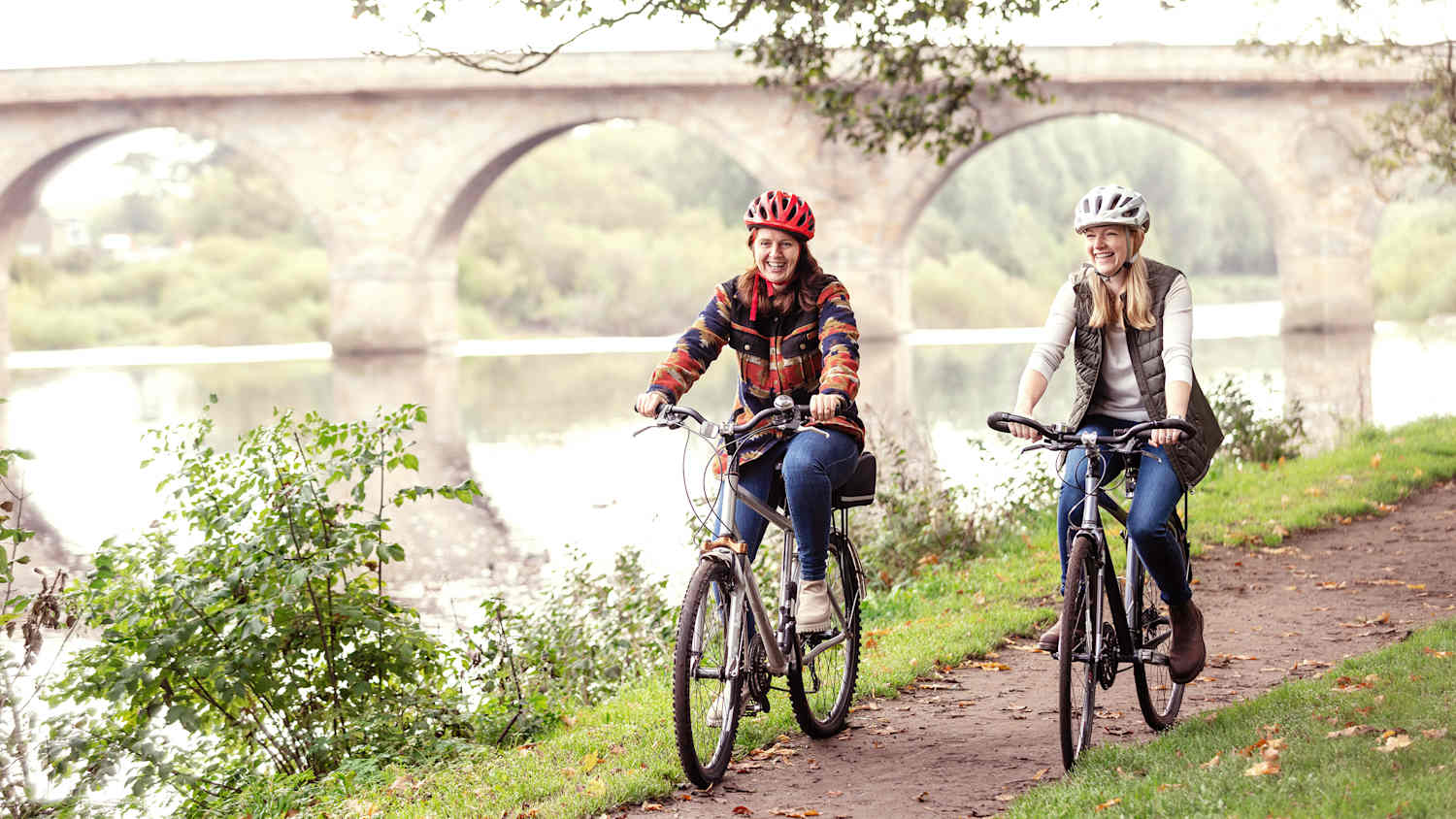 Zwei Freundinnen die in der Natur Fahrrad fahren