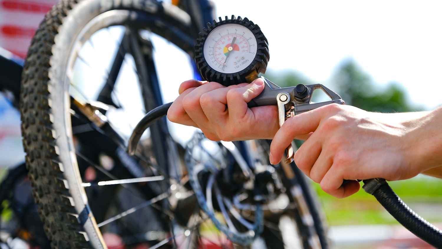 Ein Fahrrad wird mit einer Luftpumpe mit Reifendruckanzeige aufgepumpt