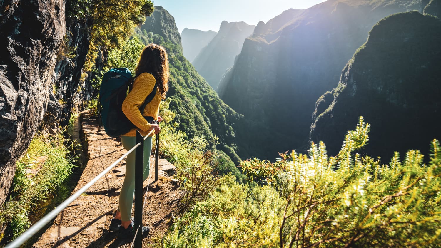 Eine junge Frau genießt beim Wandern den Blick über die Insel Madeira