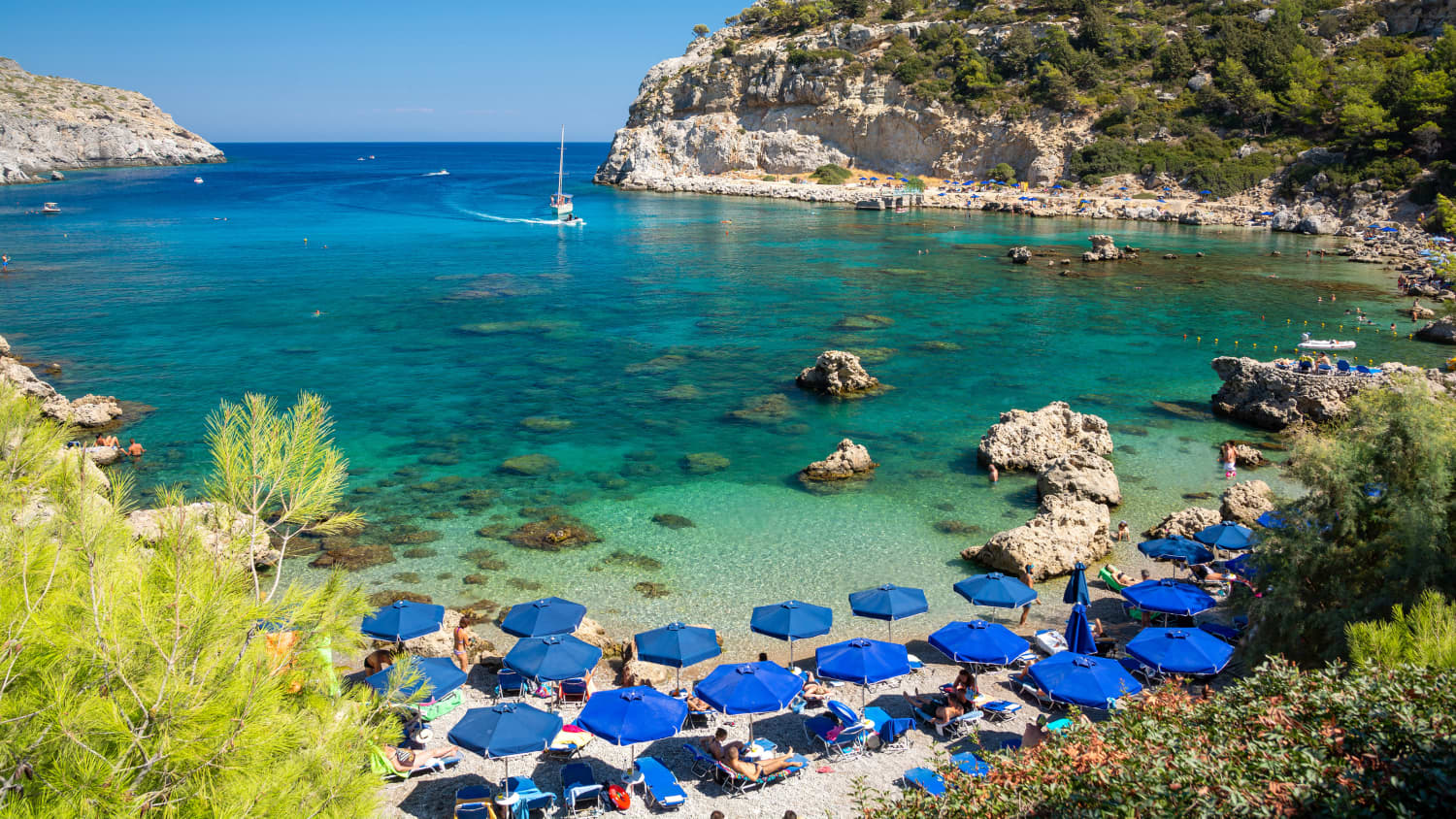 Blaue Sonnenschirme am Strand der Anthony Quinn Bucht auf Rhodos