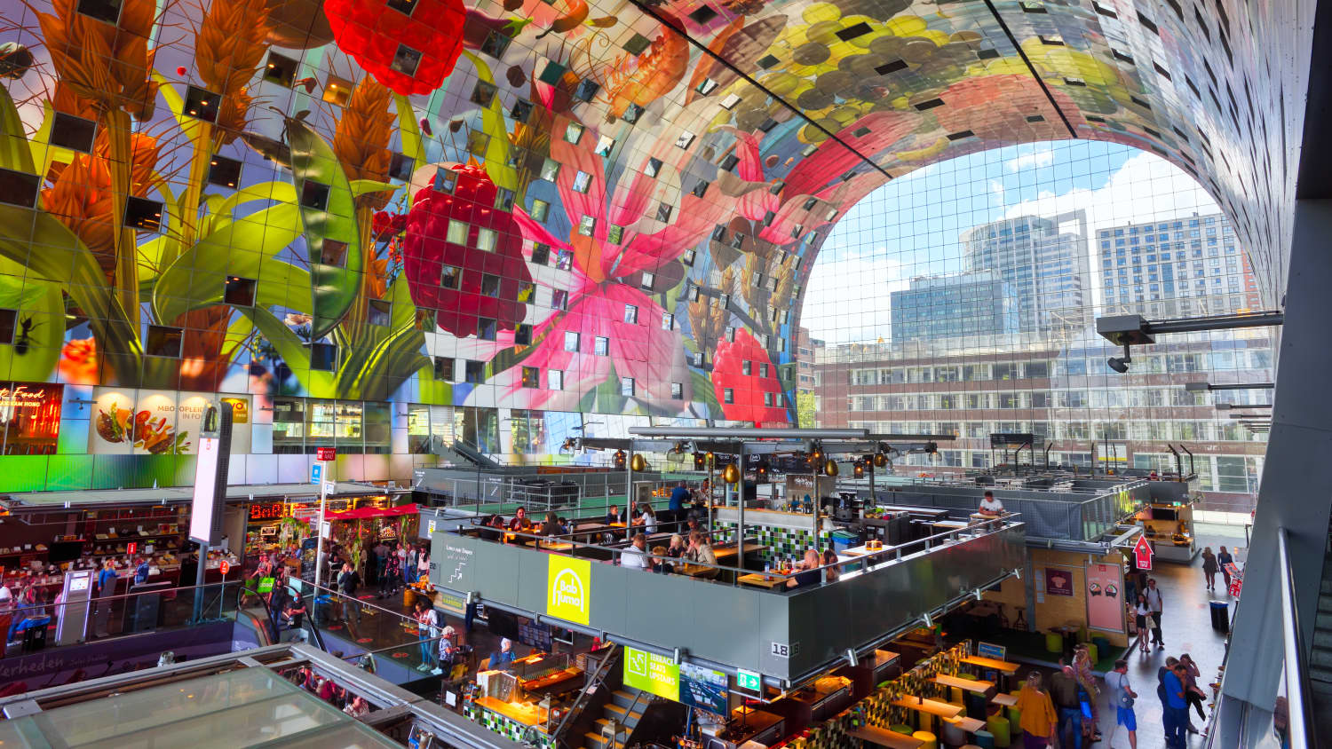 Die Markthalle zeigt ein buntes Wohn- und Bürogebäude mit Markthalle und Food-Courts