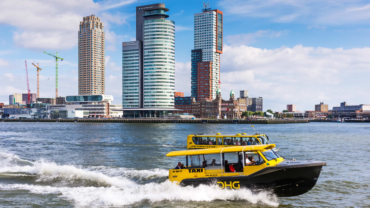 Wassertaxi und der berühmte Splash Tours-Bus auf dem Nieuwe-Maas-Kanal mit Wilhelminapier im Hintergrund