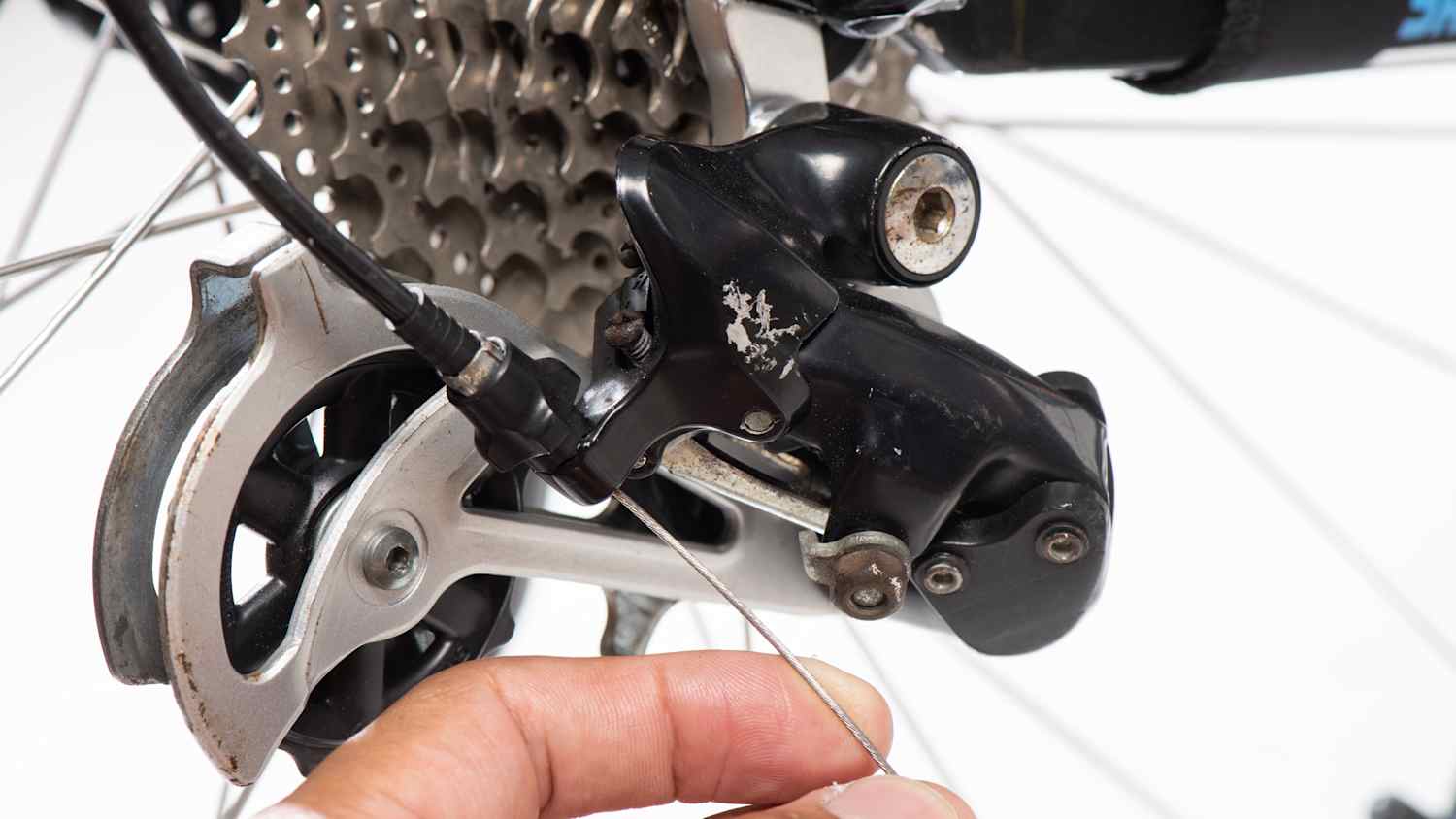 Der Schaltzug am Fahrrad wird von einem Mann repariert