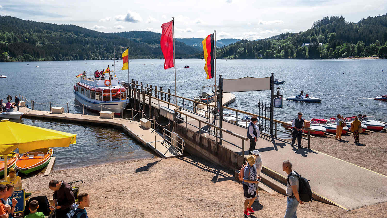 Bootssteg mit Menschen am Titisee