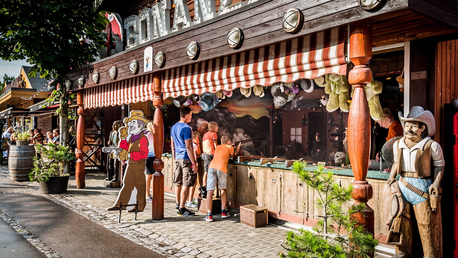 Vater und Söhne an einem Schießstand im Vergnügungspark Bakken nördlich von Kopenhagen