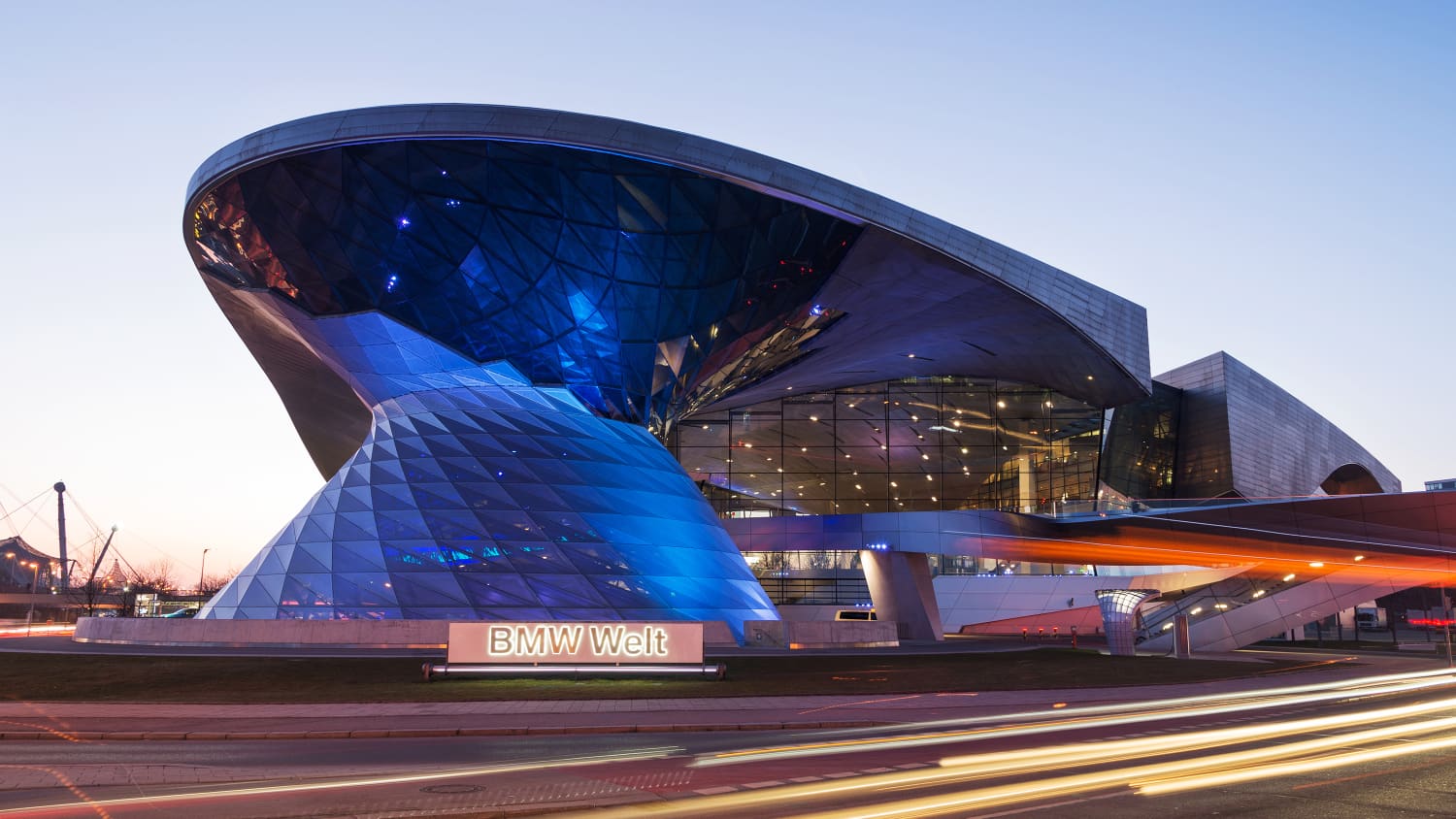 Außenansicht in der Dämmerung der blauleuchtenden BMW Welt in München