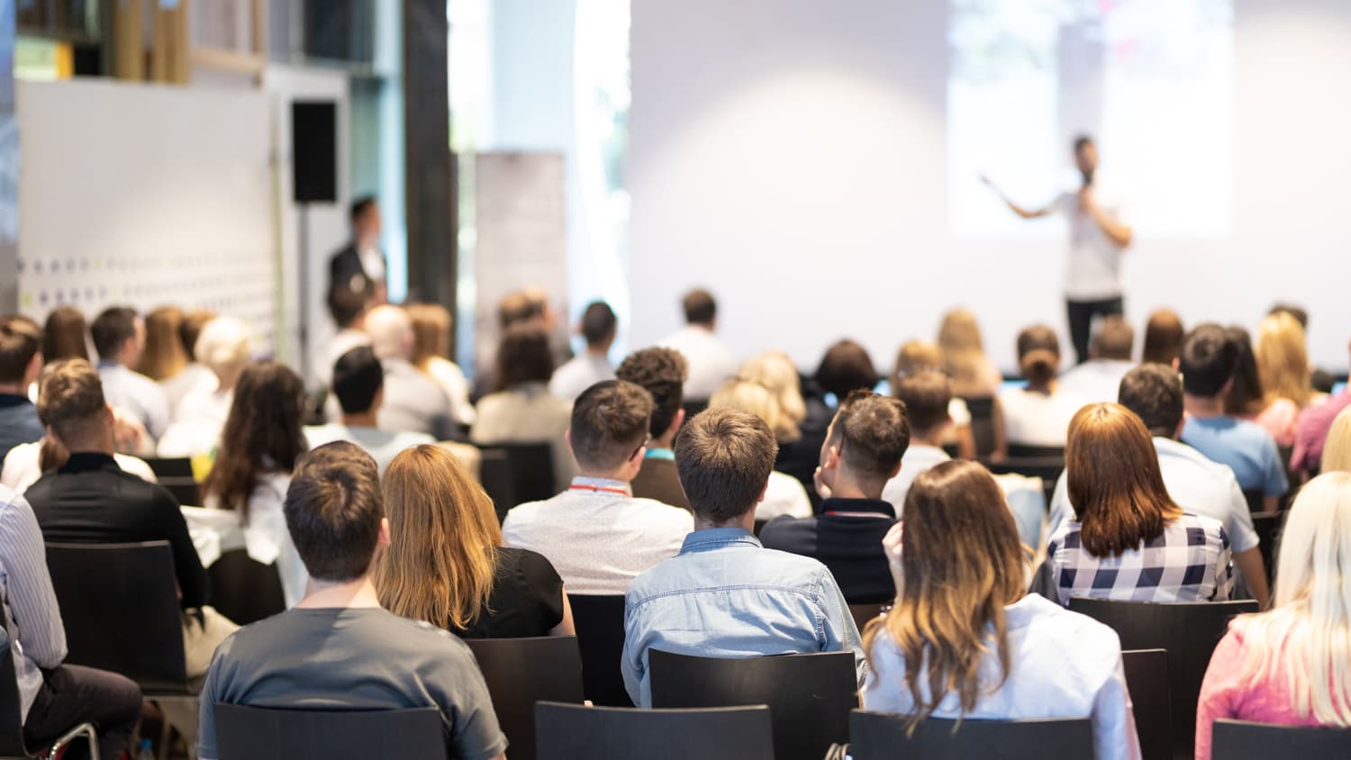 Ein Mann hält vor einem Publikum eine Rede bei einem Seminar