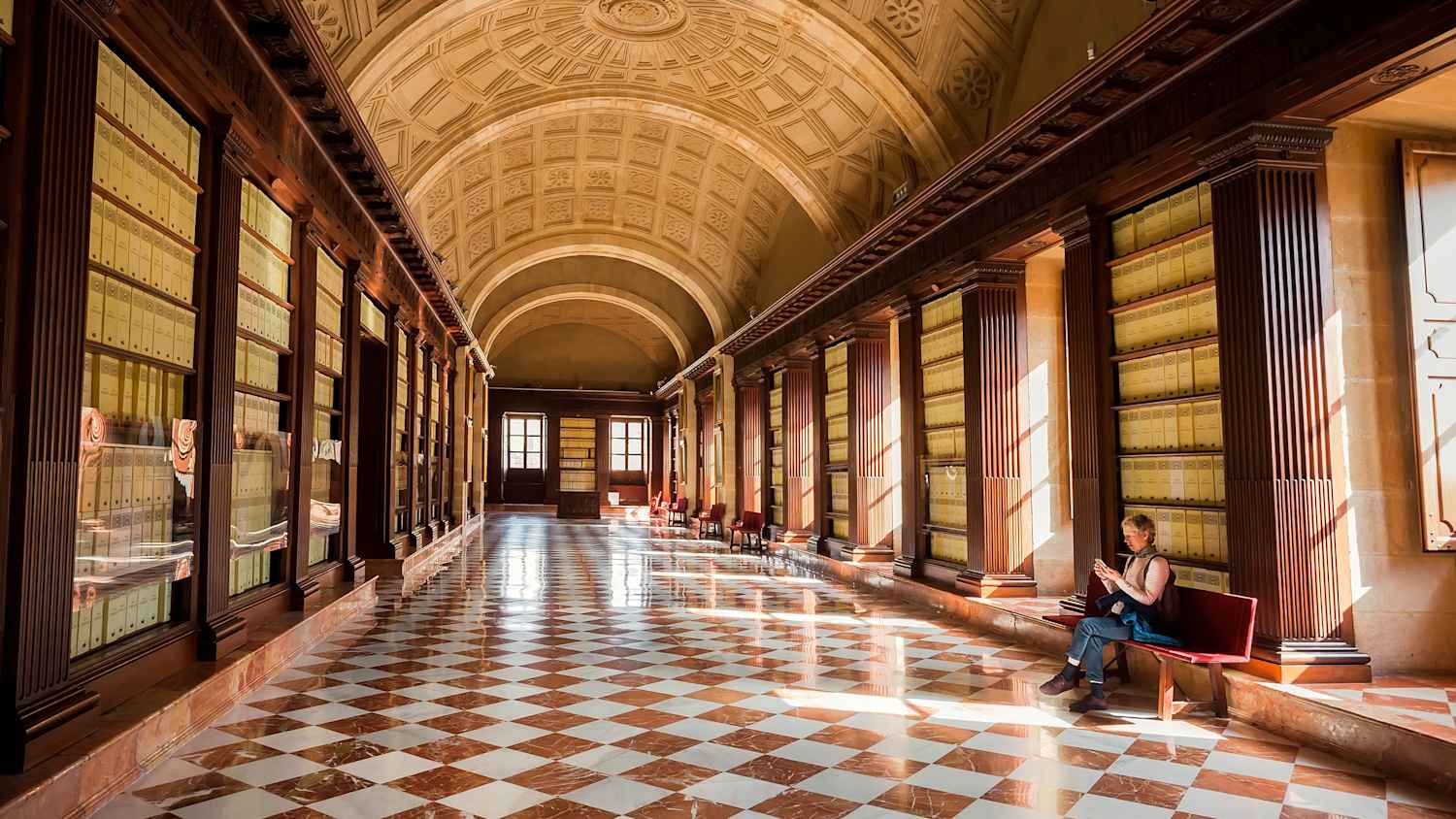 ein Besucher sitzt im Archivo General de Indias auf einer Bank