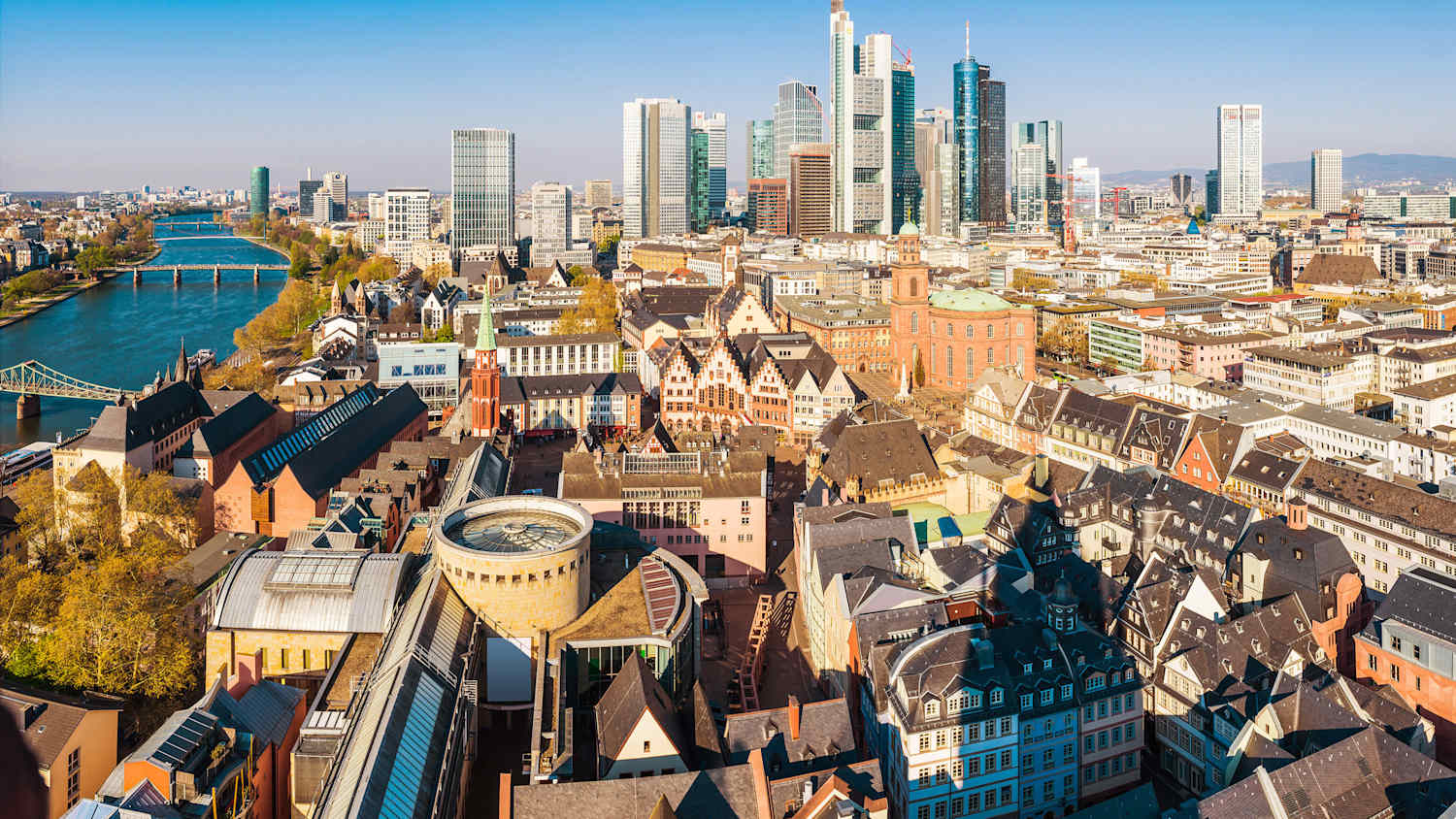 Panoramablick aus der Luft über die dynamische Skyline von Frankfurt, von den historischen Wahrzeichen der Altstadt bis zu den futuristischen Spitzen der Bankenwolkenkratzer und den Geschäften von Zeil und Hauptwache, Hessen, Deutschland.
