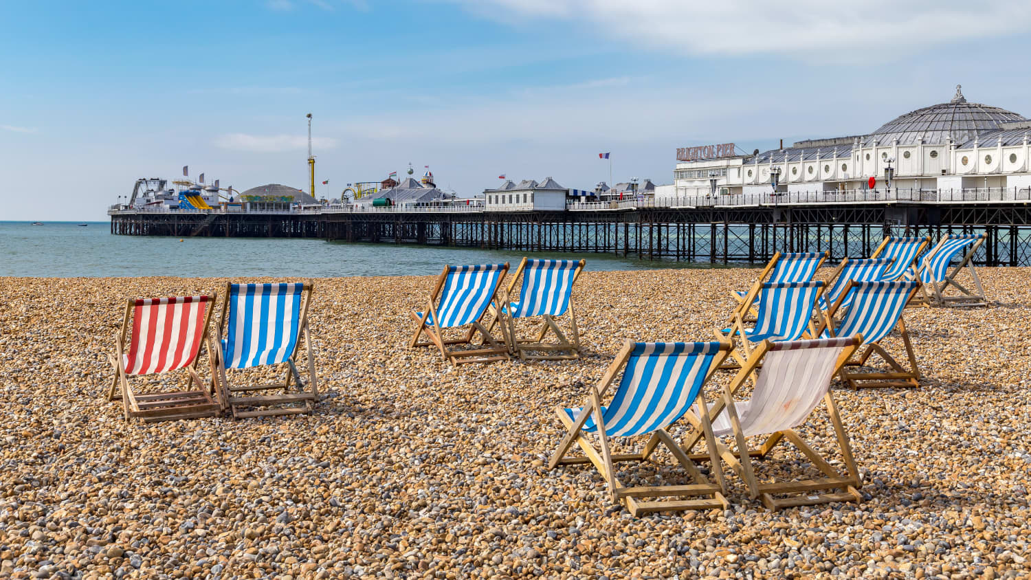 Sonnenstühle am Brighton Beach mit Pier im Hintergrund
