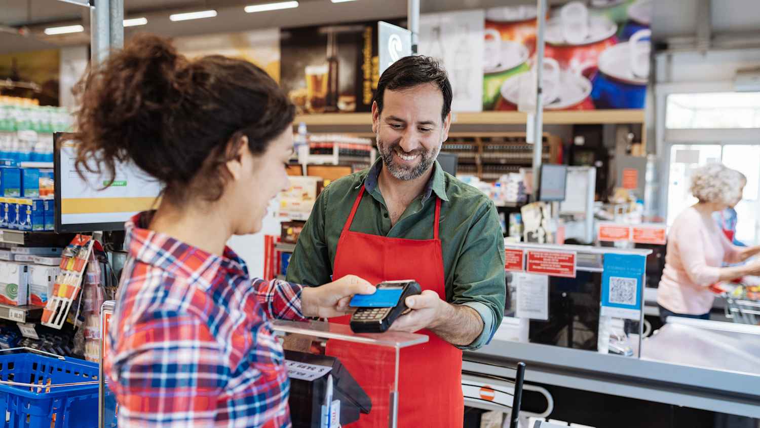 Eine Frau bezahlt im Supermarkt mit Karte