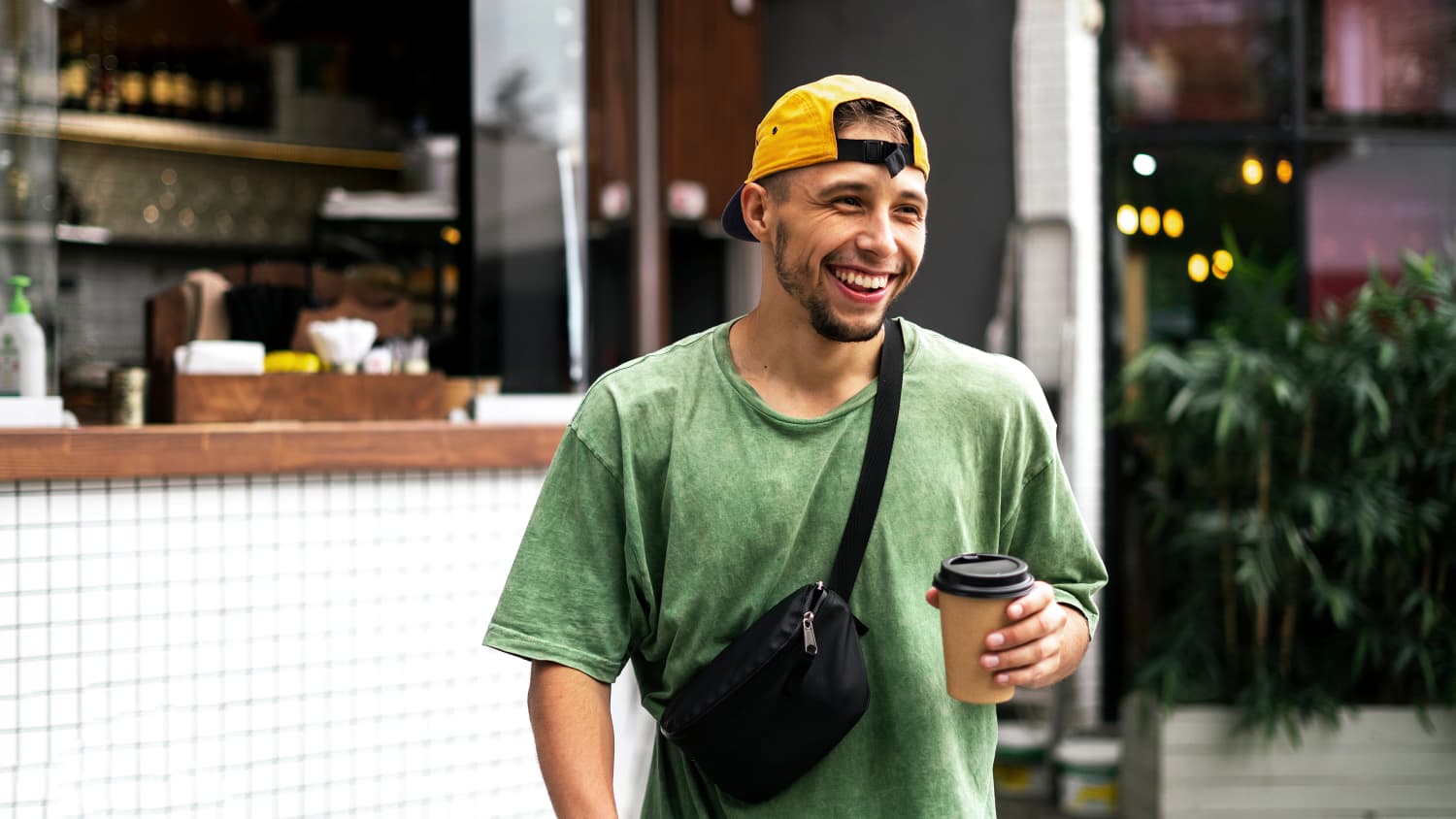 Junger Mann hält Coffee ToGo in der Hand
