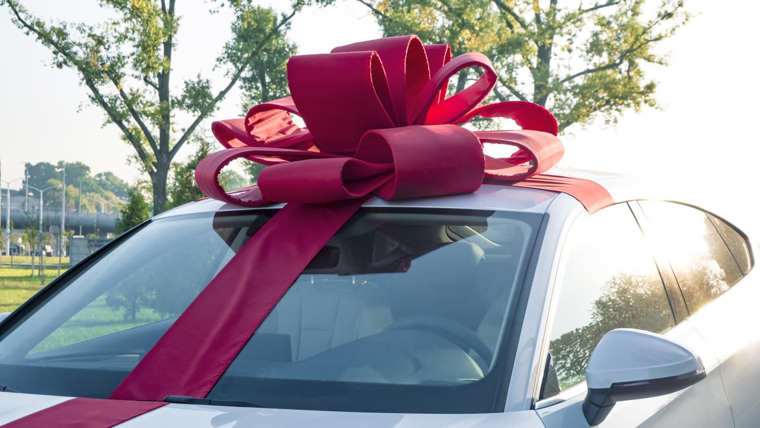 ein Auto mit einer großen Geschenkschleife auf dem Dach