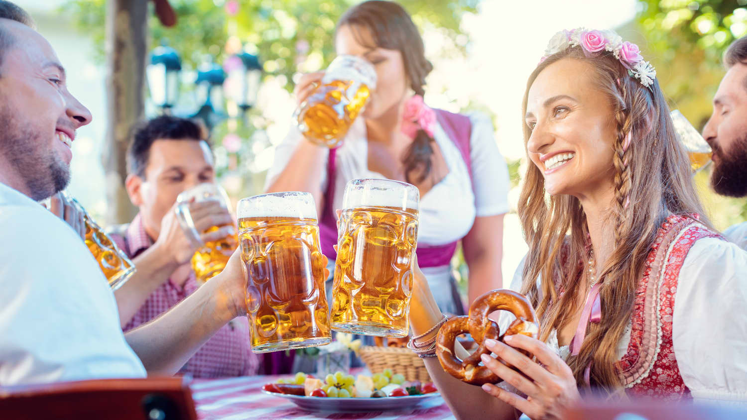 Paar schaut sich gegenseitig an und stößt mit riesigen Mengen Bier in einer bayerischen Kneipe an