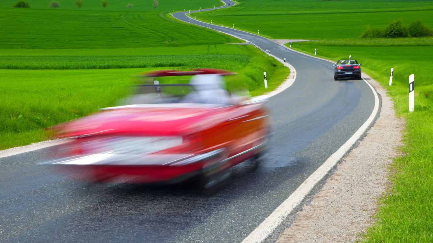 Zwei Autos fahren auf einer Landstraße