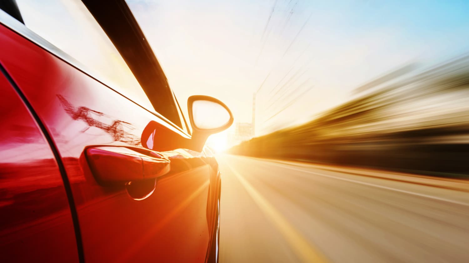 Seitenansicht eines roten schnellfahrenden Autos.