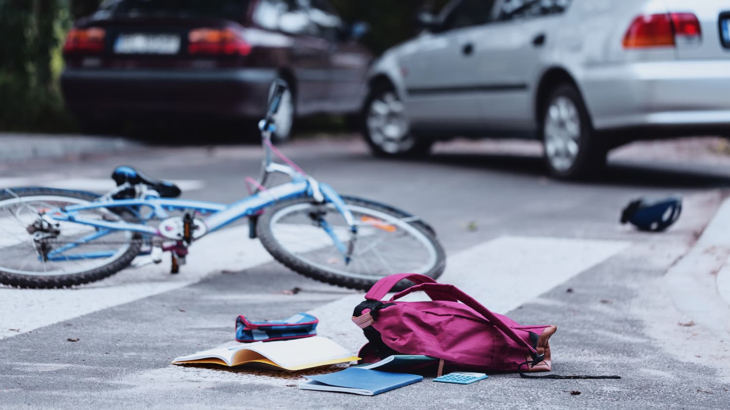 Unfallszene mit Fahrrad und Schulranzen und einem Auto