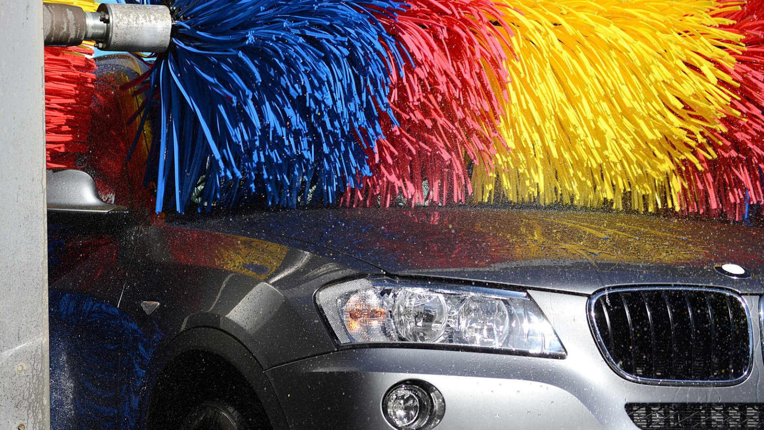 Bürste einer Waschanlage säubert die Kühlerhaube eines Autos