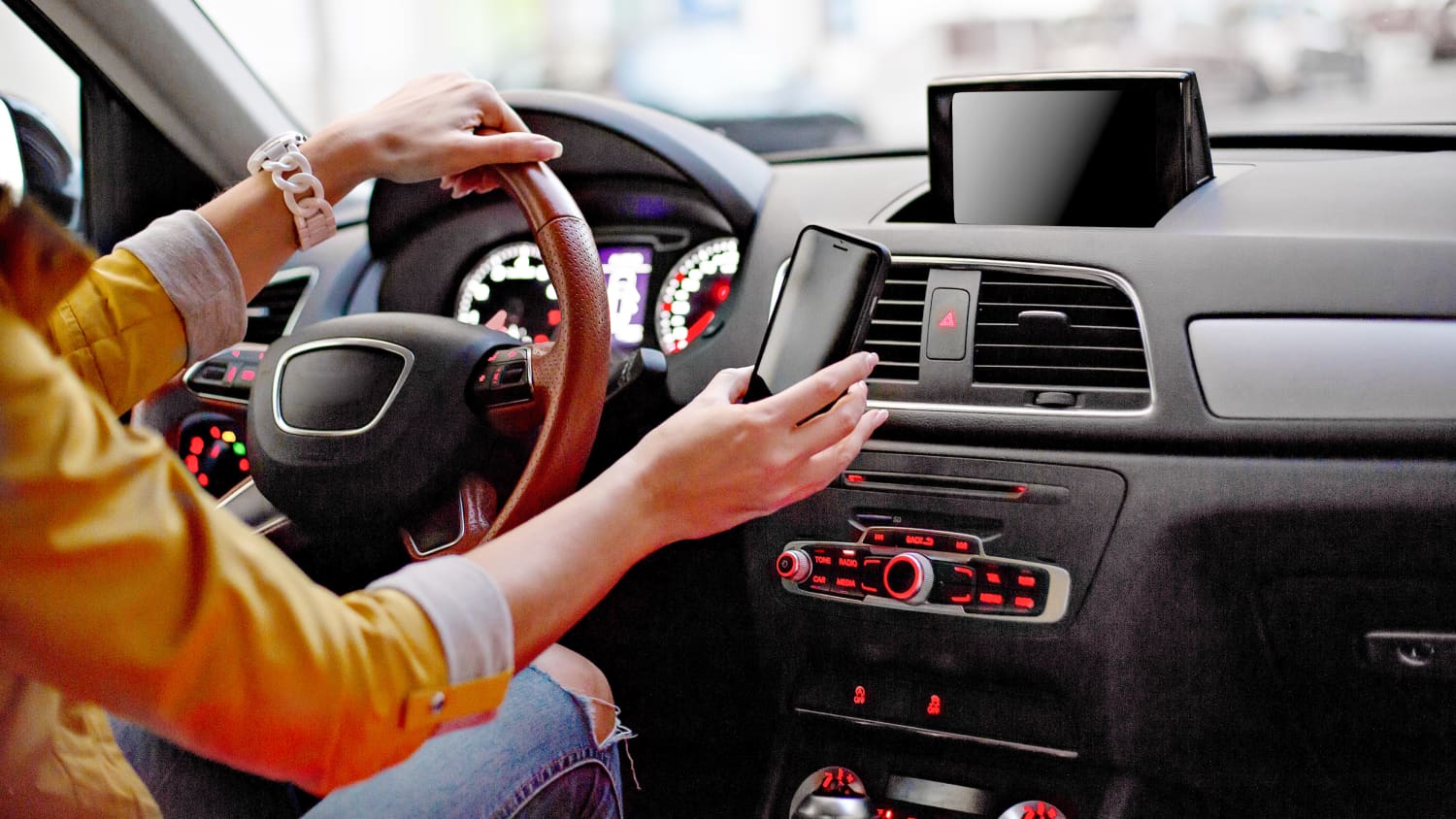 Frau hat im Auto Ihr Handy in der Hand