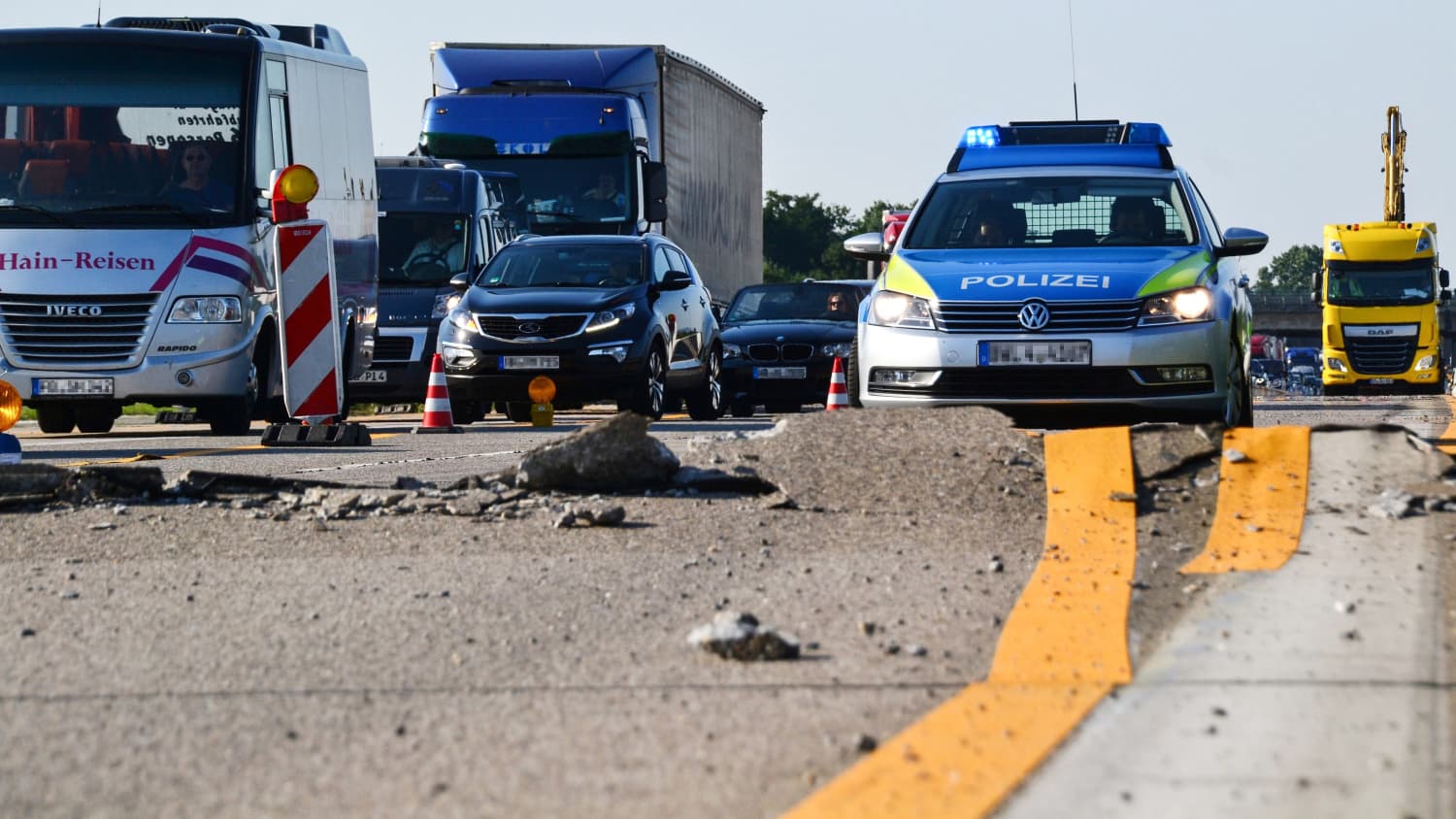 Ein Polizeiauto steht vor einer aufgerissenen Strasse